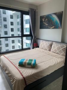 a bedroom with a bed with a large window at Base Condos in Pattaya South
