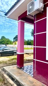 ein rosafarbenes Gebäude mit einem Ventilator darüber in der Unterkunft Nazla Homestay Pendang 2 in Pendang