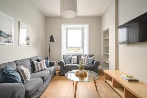 un soggiorno con divano e tavolo di 2BR New Town Castle View Apartment a Edimburgo