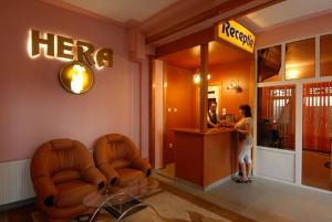 a woman standing at a hotel reception desk at Villa Hera in Băile Herculane +32 photos