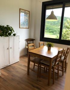 d'une salle à manger avec une table, des chaises et une fenêtre. dans l'établissement Casa adosada con gran jardín en Osséja, à Osséja