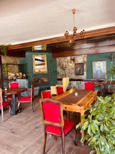 jadalnia z drewnianym stołem i czerwonymi krzesłami w obiekcie Hotel Neda Galichnik w mieście Galičnik