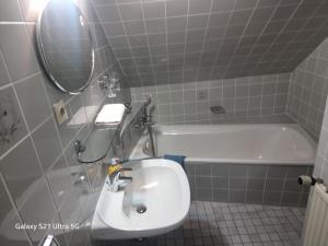 a bathroom with a sink and a tub and a mirror at 1A Hotel Zimmer frei in Spremberg