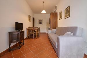 a living room with a couch and a television at Antichi Palmenti - Corbezzolo in San Vincenzo