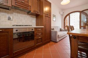 a kitchen with wooden cabinets and a stove top oven at Antichi Palmenti - Corbezzolo in San Vincenzo