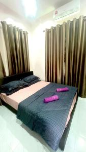 2 rosa Kissen auf einem Bett im Schlafzimmer in der Unterkunft Nazla Homestay Pendang 2 in Pendang