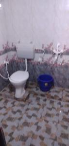 baño con aseo y cubo azul en Coco Beach Gokarna en Gokarna
