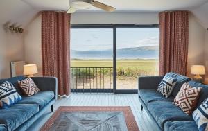 a living room with a couch and a view of the ocean at Beach House in Pennygown