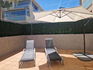 - 2 chaises et un parasol sur la terrasse dans l'établissement Torremolino's paradise, à Torremolinos