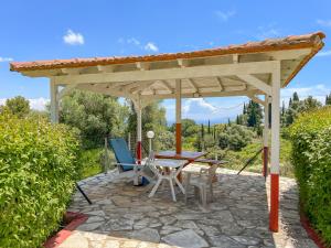 a patio with a table and chairs under a pavilion at Amazona Apartments and Studios in Spartià