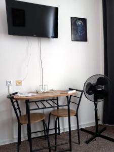 einen Schreibtisch mit Stühlen und einen TV an der Wand in der Unterkunft Penzión Šariš in Prešov