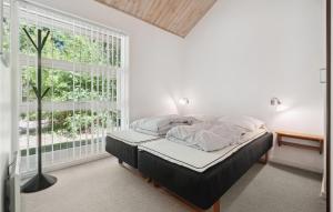 1 dormitorio con cama y ventana grande en Rubinsen Skovhuse, en Hasle