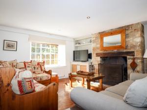 a living room with a couch and a fireplace at 1 The Lane in Chipping Norton
