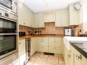 a kitchen with white cabinets and white appliances at 1 The Lane in Chipping Norton
