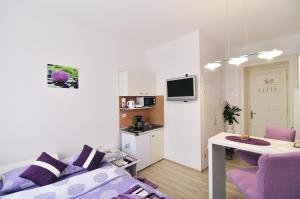 a living room with a purple couch and a kitchen at Apartments Trend in Rijeka