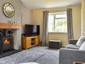 a living room with a fireplace and a tv at The Drive in Newton Reigny