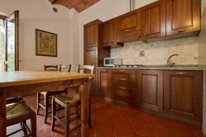 a kitchen with wooden cabinets and a wooden table at Antichi Palmenti - Erica in San Vincenzo