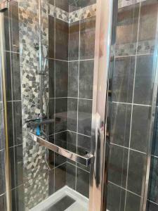een douche met een glazen deur in de badkamer bij Maison entre ville et montagne in Valdoie