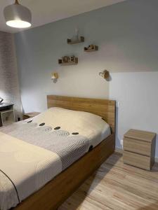 een slaapkamer met een bed en een witte muur bij Maison entre ville et montagne in Valdoie