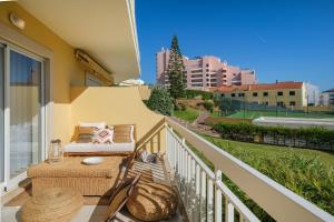 a balcony with a table and chairs and a view of a city at Sea Lux Ericeira Beach in Ericeira