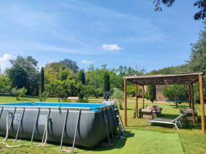 una piscina en un jardín con cenador en La Pallissa - Can Bonet, en Sant Martí Vell