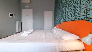 a bedroom with a large white bed with an orange headboard at Locanda Al Volo Tor Bandena in Trieste +56 photos