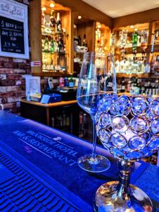 two wine glasses sitting on top of a bar at Brookside Hotel & Restaurant ,Suitable for Solo Travelers, Couples, Families, Groups Education trips & Contractors welcome in Chester
