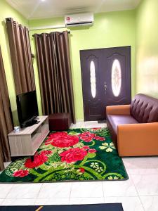ein Wohnzimmer mit einem Sofa und einer Tür mit einem Blumenteppich in der Unterkunft Nazla Homestay Pendang 2 in Pendang
