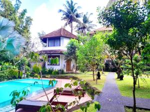 a villa with a swimming pool and a house at Hotel rooms 2 minutes to Monkey Forest in Ubud