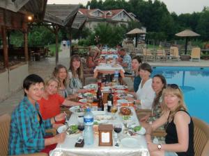 un grupo de personas sentadas en una mesa junto a una piscina en Sedir Resort - Hotel Rooms, Bungalows & Suites, en Dalyan