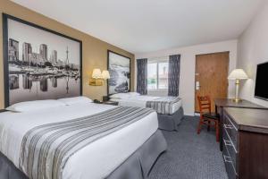 a hotel room with two beds and a desk at Super 8 by Wyndham Guelph in Guelph