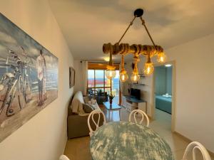 a living room with a dining table and a chandelier at Apto One More Day in Ambar in Calpe