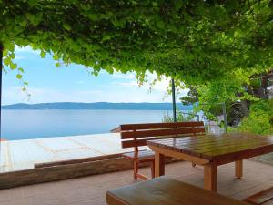 a picnic table and bench on a dock with a lake at relax in Marusici 