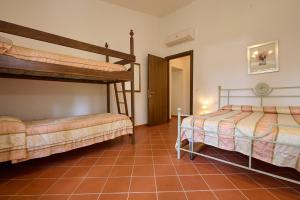 een slaapkamer met 2 stapelbedden en een tegelvloer bij Antichi Palmenti - Rosmarino in San Vincenzo