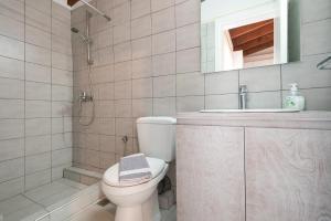 W łazience znajduje się toaleta, umywalka i prysznic. w obiekcie Castle View Apartments w mieście Myrina