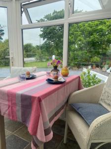 een tafel in een serre met een roze tafelkleed bij Barrow Harbour studio apartment in Tralee