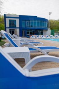 a row of lounge chairs in front of a pool at Black Sea Hotel Otrada in Odesa
