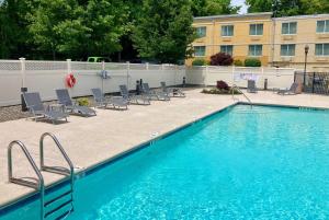 a large swimming pool with chairs and a building at La Quinta by Wyndham Danbury in Danbury