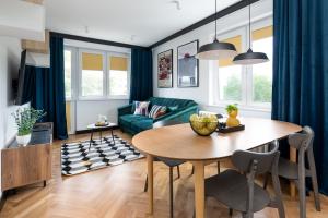 salon ze stołem i zieloną kanapą w obiekcie Modernizmo by 3City Rentals w mieście Gdynia