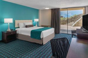 Habitación de hotel con cama y puerta corredera de cristal en Hotel 505 en Albuquerque