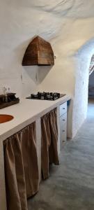a kitchen with a white counter with brown chairs at Cuevas Los Coloraos - La Cuadra in Villanueva de las Torres