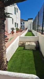 a house with a yard with green grass at Bungalows Boston in Puerto Rico de Gran Canaria