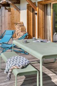 a table and two chairs on a wooden deck at Rochebrune - Appartement de luxe in Megève