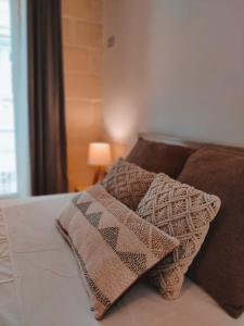 a bed with two pillows and a blanket on it at Walter's B&B in Il-Gżira