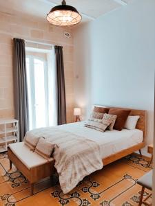 a bedroom with a large bed and a window at Walter's B&B in Il-Gżira