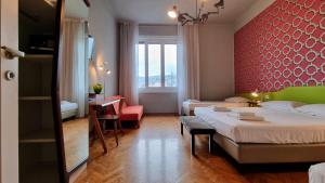 una camera d'albergo con letto, tavolo e scrivania di Locanda Al Volo Tor Bandena a Trieste