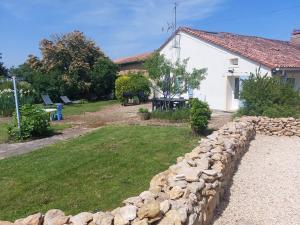 un jardin avec un mur en pierre et un bâtiment dans l'établissement Gîte le Hameau des Bordes 4 étoiles, à Nouaillé-Maupertuis