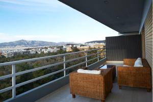 einen Balkon mit 2 Stühlen und Stadtblick in der Unterkunft Luxury Apartment with Exceptional View in Athen
