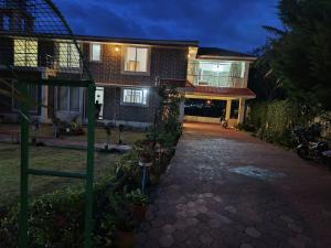 a house with a driveway in front of it at Velus Bungalow Ooty in Ooty