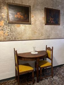 a wooden table and two chairs with a wine glass on it at The Prince of the Old Town Masserano in Masserano